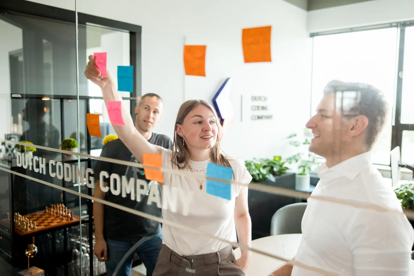 Ideeën ordenen met sticky notes op een glazen wand