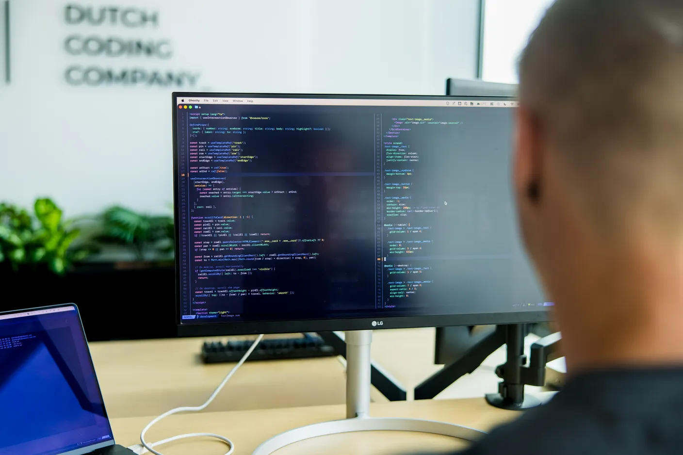 Een developer bekijkt code op een groot scherm
